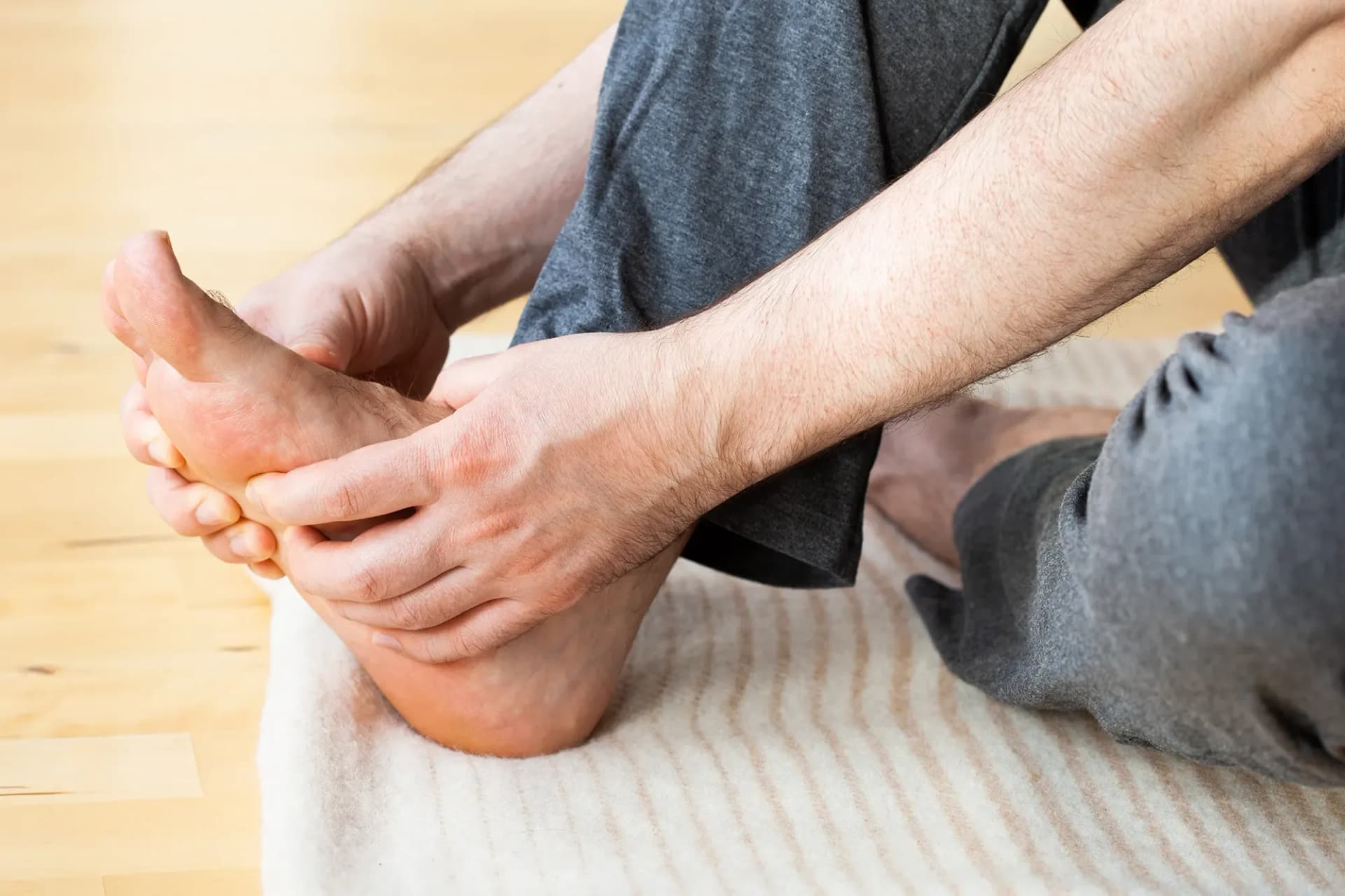 A person holds a sore foot