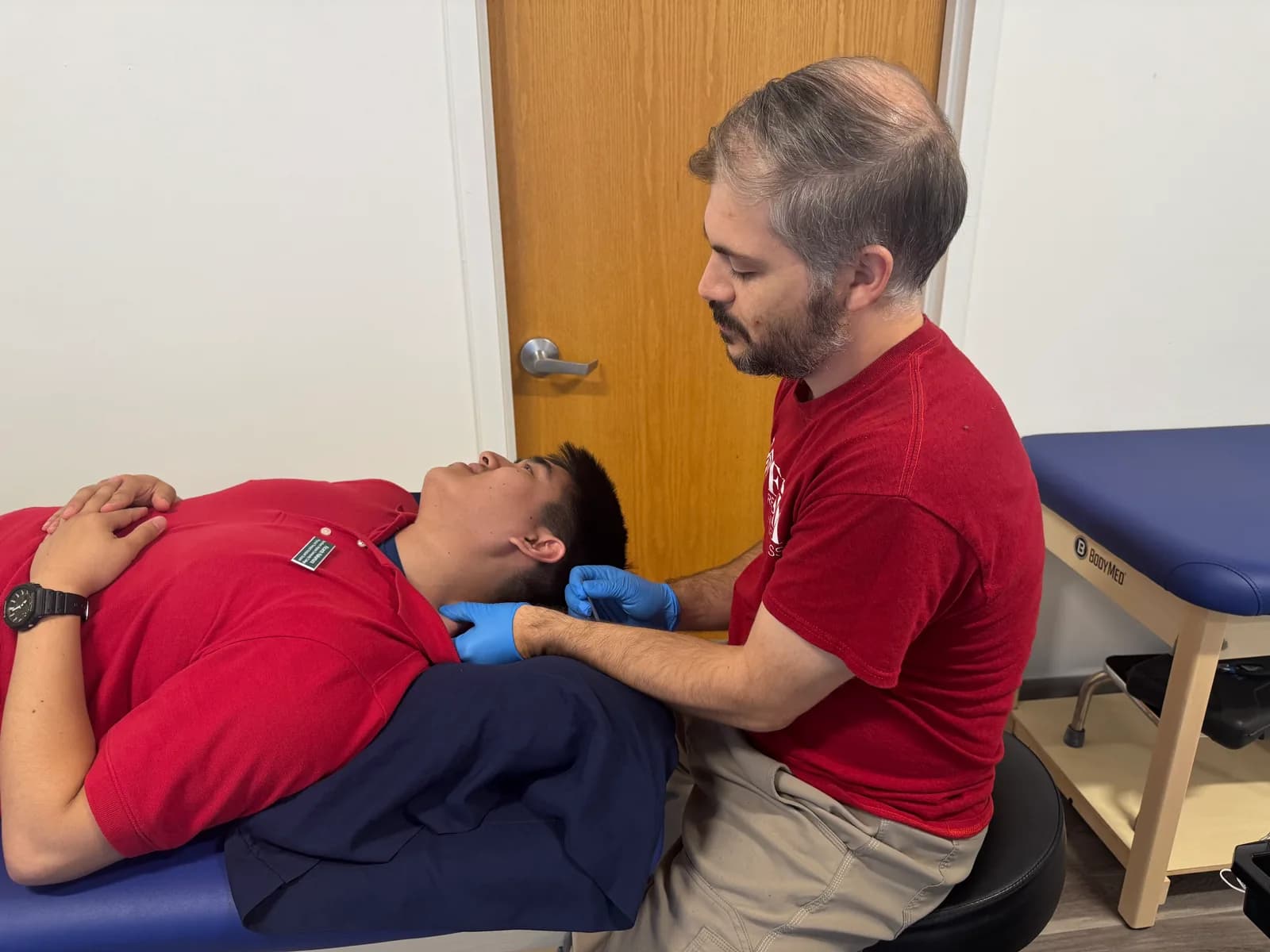Dry-needling demonstration on a treatment table.