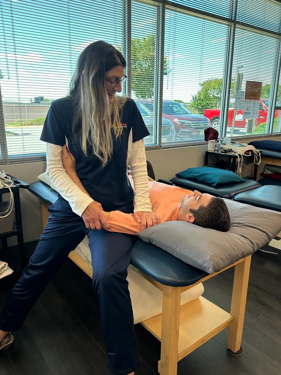 Hands-on guidance of an arm movement on a treatment table.