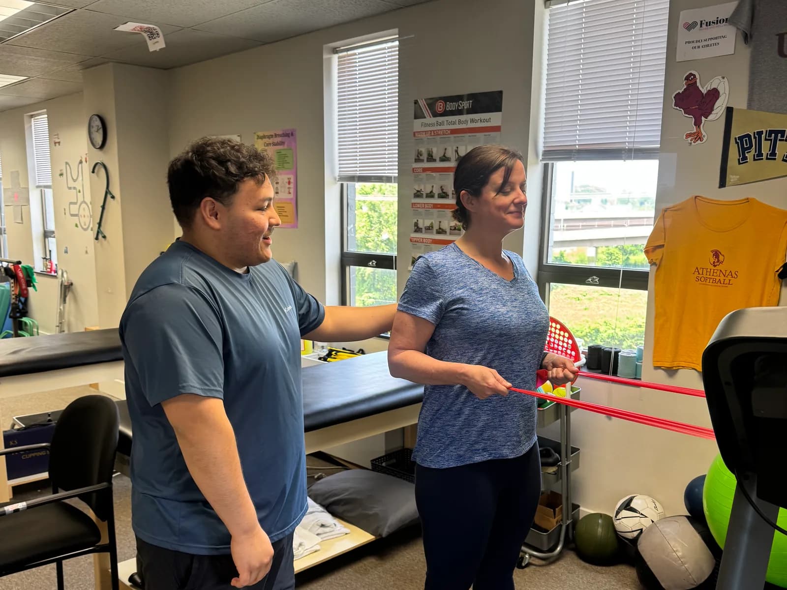 Guided resistance-band exercise inside a Fusion clinic.